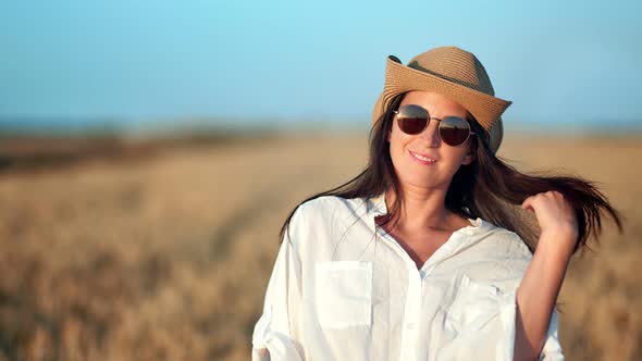 Smiling Cowboy Travel Female Posing Surrounded By Wheat Field Playing with Hair Looking at Camera alt