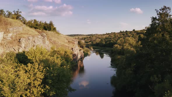 Aerial Shot with Drone Flying Close to the Water in Canyon During Sunny Day alt