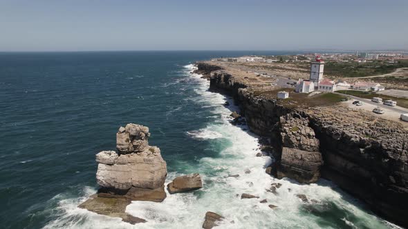 Drone orbit around Lighthouse of Cabo Carvoeiro, dramatic cliffs with sea stack