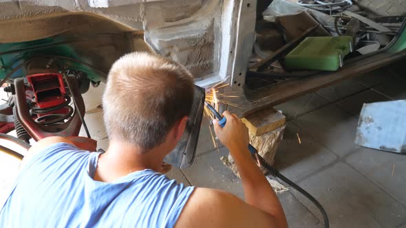 Unrecognizable Repairer Wearing Protective Mask Welding Some Detail of Auto alt