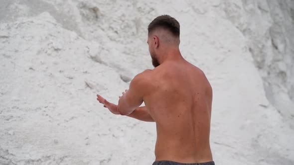 Muscular shirtless man showing his body on the natural background of mountains. alt