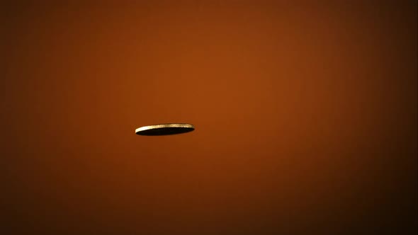 Golden coin flipping in the air in ultra slow motion  alt