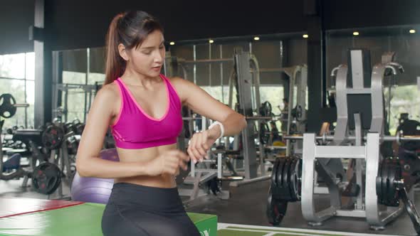 Asian healthy sport woman wearing smartwatch device check heart rate result after workout.