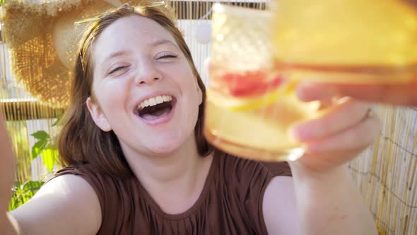 Happy Girl Shoots Video with Mobile Phone Holding Cocktail