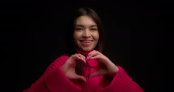 Pretty Girl Shows a Heart Sign to the Camera Expressing Her Love