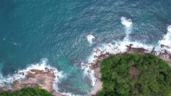 Aerial view slow motion waves crashing on rocky stones with splashing and white foam at Phuket alt