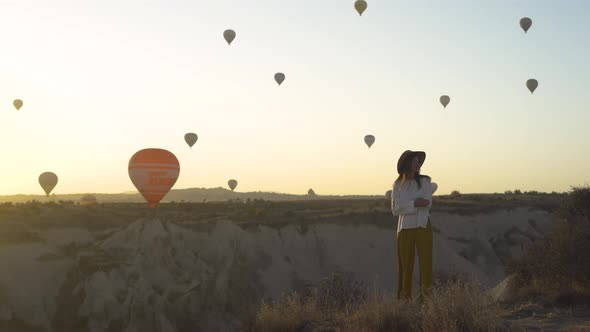 Travelling Girl Watching the Sunrise and Hot Air Balloons