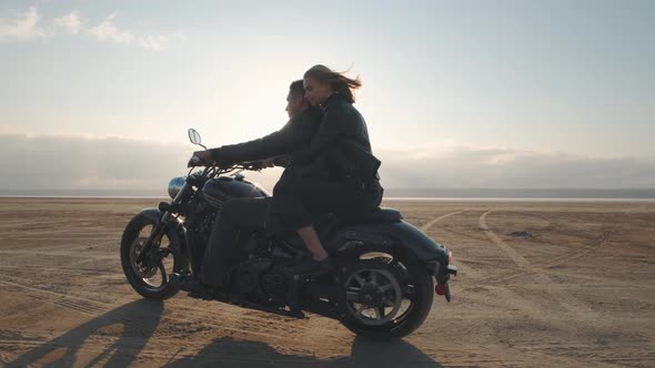 Guy with a Girl on a Motorcycle in the Desert alt