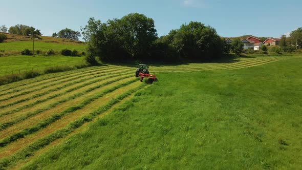 Silage Harvester Driven On Vast Green Field In Hjelmeland Norway - aerial shot alt