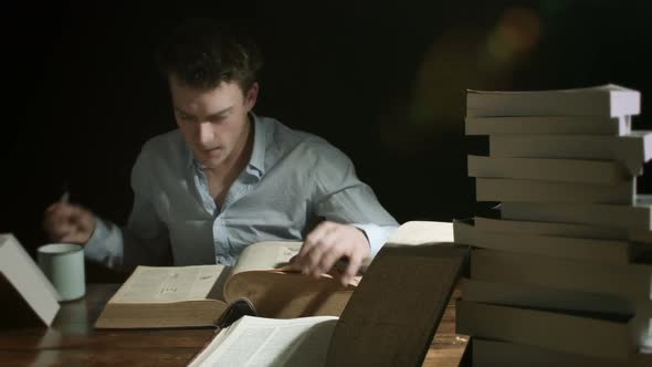 Man Working Late and Searching into Old Big Books