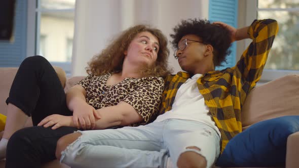 Tired Diverse Couple Relaxing o Couch and Watching Tv at Home alt