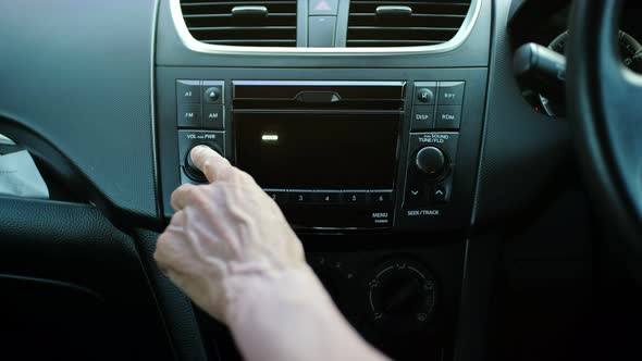 Man hand turning on radio in car. audio concept