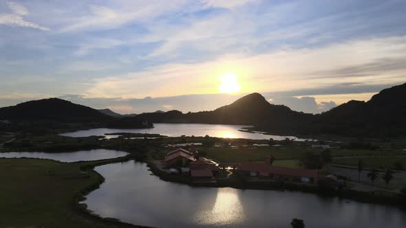 Sunset over stunning landscape of mountains and lake, wide angle aerial view alt