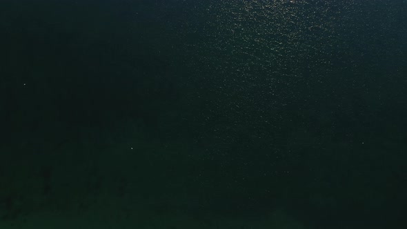 Drone Shot of Vast Sea Water with Bright Sunbeam Reflecting on the Waters alt