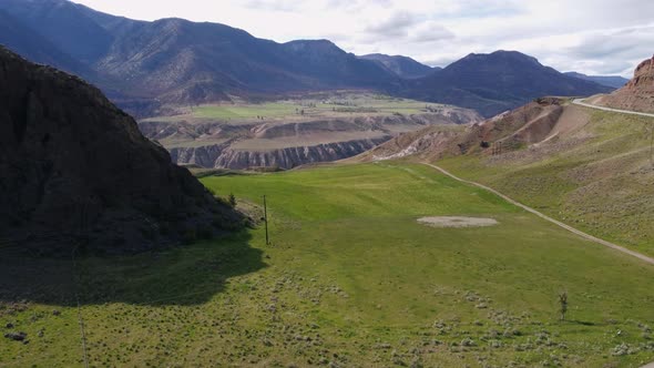Drone rises up over hills alt