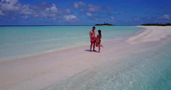 Young lady and man on honeymoon vacation enjoy life on beach on paradise white sand background  alt