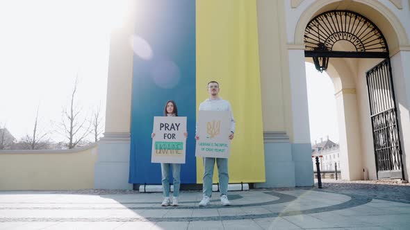 People Stand with Posters Against War Against the Flag of Ukraine