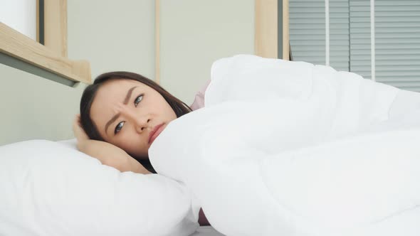 Woman waking up and irritated from noisy in bedroom alt
