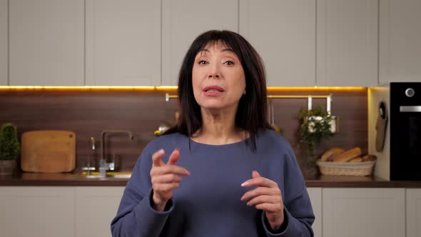 Aged Woman Talking Online Remote Video Call Webcam View Laptop in Home Kitchen alt