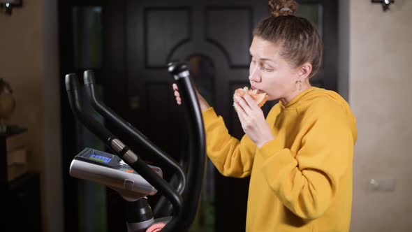 Lazy workout on an ellipsoid at home and eating a burger alt