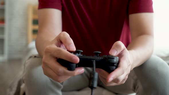 Close Up of Young Man Holding Game Controller While Playing Video Console Game at Home alt