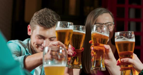 Group of Happy Friends Having Fun Together Drinking Beer and Clinking Their Glasses Celebrating alt
