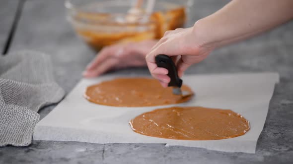 Spreading the Raw Caramel Dough Over a Baking Sheet Parchment Paper