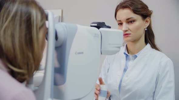 The Ophthalmologist Examines the Patient's Eye and Then Looks Into the Camera alt