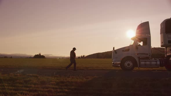 Truck driver walking to truck at sunset.  Fully released for commercial use.