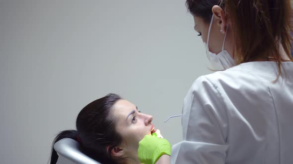 Stomatologist Using Water Syringe to Clean the Patient's Mouth alt