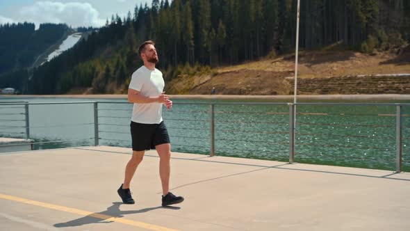 Young man running fast and intense in forest alt