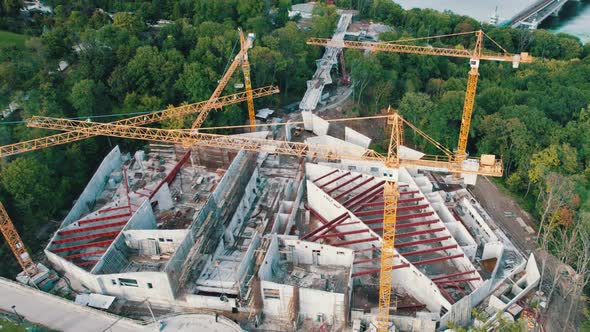 Aerial View Construction of a New Building with High Tower Cranes in Green Area alt