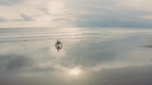 Tourist on Motorbike Crossing Empty Tropical Beach alt