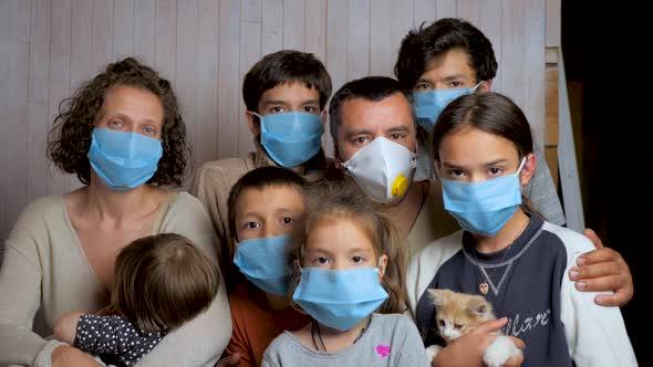 Portrait of a Family Having Six Children in Protective Medical Masks on a Background of a Wooden alt