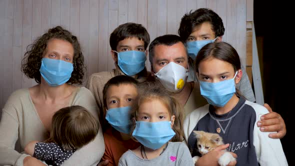 Portrait of a Family Having Six Children in Protective Medical Masks on a Background of a Wooden