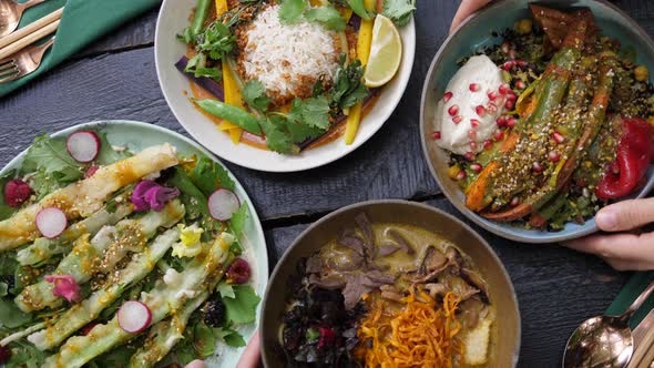 Serving Two Plates with Healthy Organic Vegan Meals To the Black Wooden Table