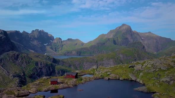 A Flight Over A Lake And A Small House In The Beautiful Mountains Of The Lofoten Islands alt