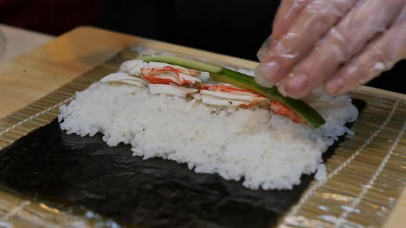 the Hands of the Sushi Chef Spin a Roll of Rice Squid Meat Cucumber and alt