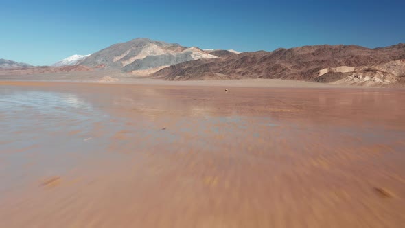 Epic Rapid Flying Back From Stone with Race Track on the Wet Surface of Desert alt