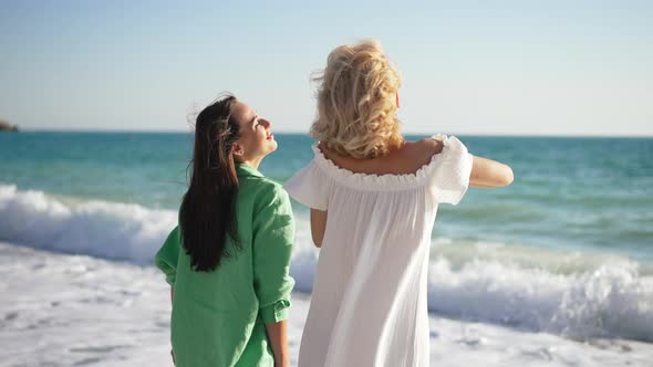 Two Excited Caucasian Young Slim Beautiful Women Admiring Picturesque Mediterranean Sea Talking and alt