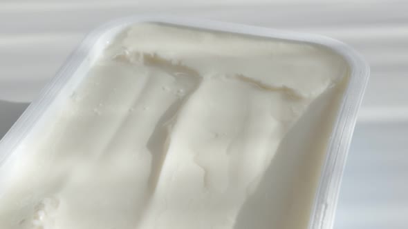 Slow tilt over cream cheese in plastic box 4K video alt