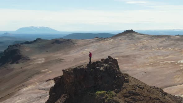 Photographer Man Traveler on Mountain Top Taking Pictures. Iceland. Aerial View alt