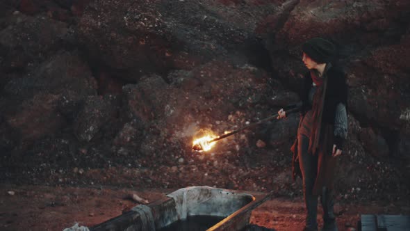 Woman Putting Torch in Bathtub with Water in Post Apocalyptic World alt