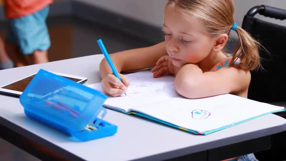 Disabled schoolgirl studying in classroom alt