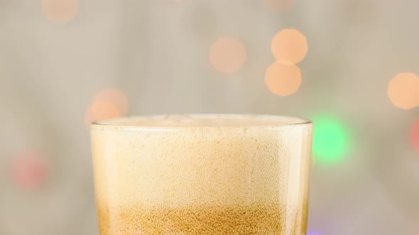 A carbonated sweet drink is poured into a glass. Bubbles close up.