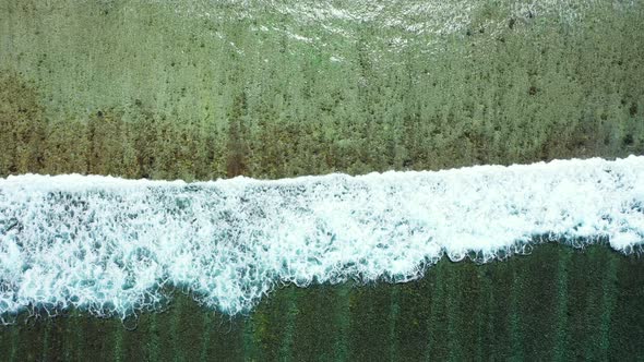 Rough waves crashing into the shoreline in Barbados captured from the air alt