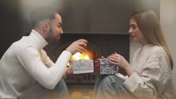 Romantic Holiday Cheerful Guy and a Female Give Each Other Boxes with Gifts a Young Couple is alt