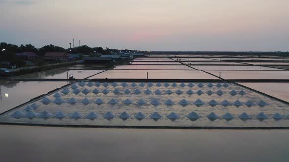 Aerial view of heaps of raw sea salt piles with sea. Farm field outdoor. Nature material in salt alt