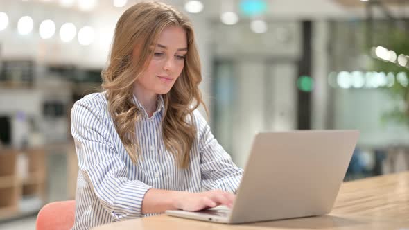Focused Businesswoman Working on Laptop in Office  alt