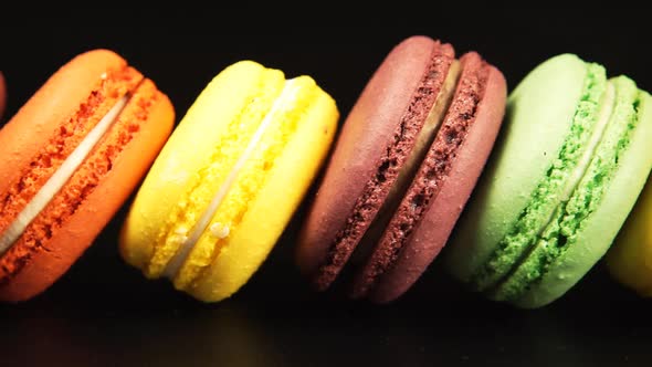 A row of a colorful macaroons is on the black background